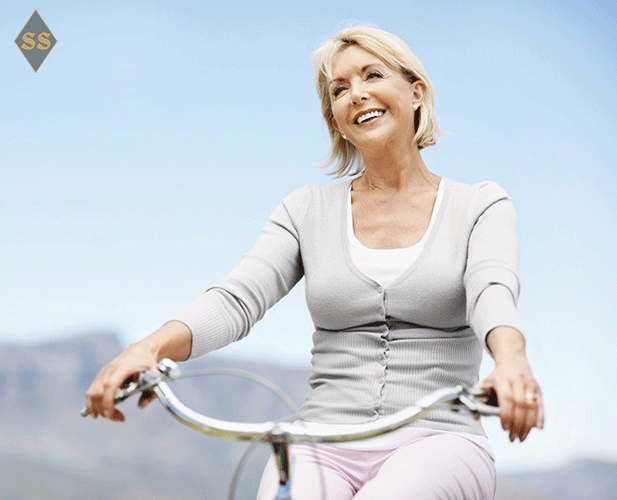 улыбающаяся женщина сидит на велосипеде